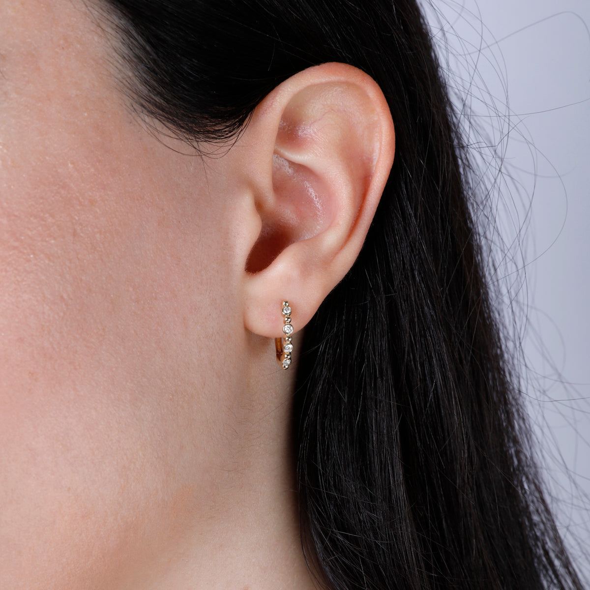 Bethany Diamond Hoop crafted in gold and adorned with round diamonds to create a simplistic pattern.