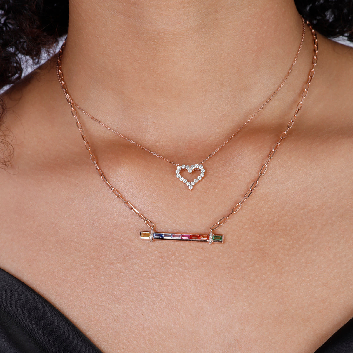 Candy Stripe Multicolor Necklace, a 14k gold bar adorned with a row of vibrant sapphire stones.