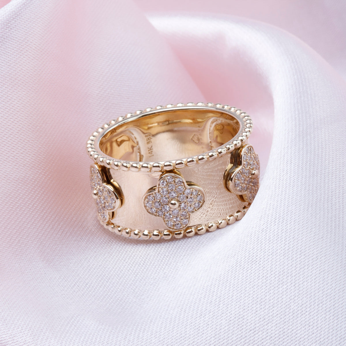 Discover elegance with the Alhambra Wide Band ring in 14k gold, encrusted with sparkling diamonds. 