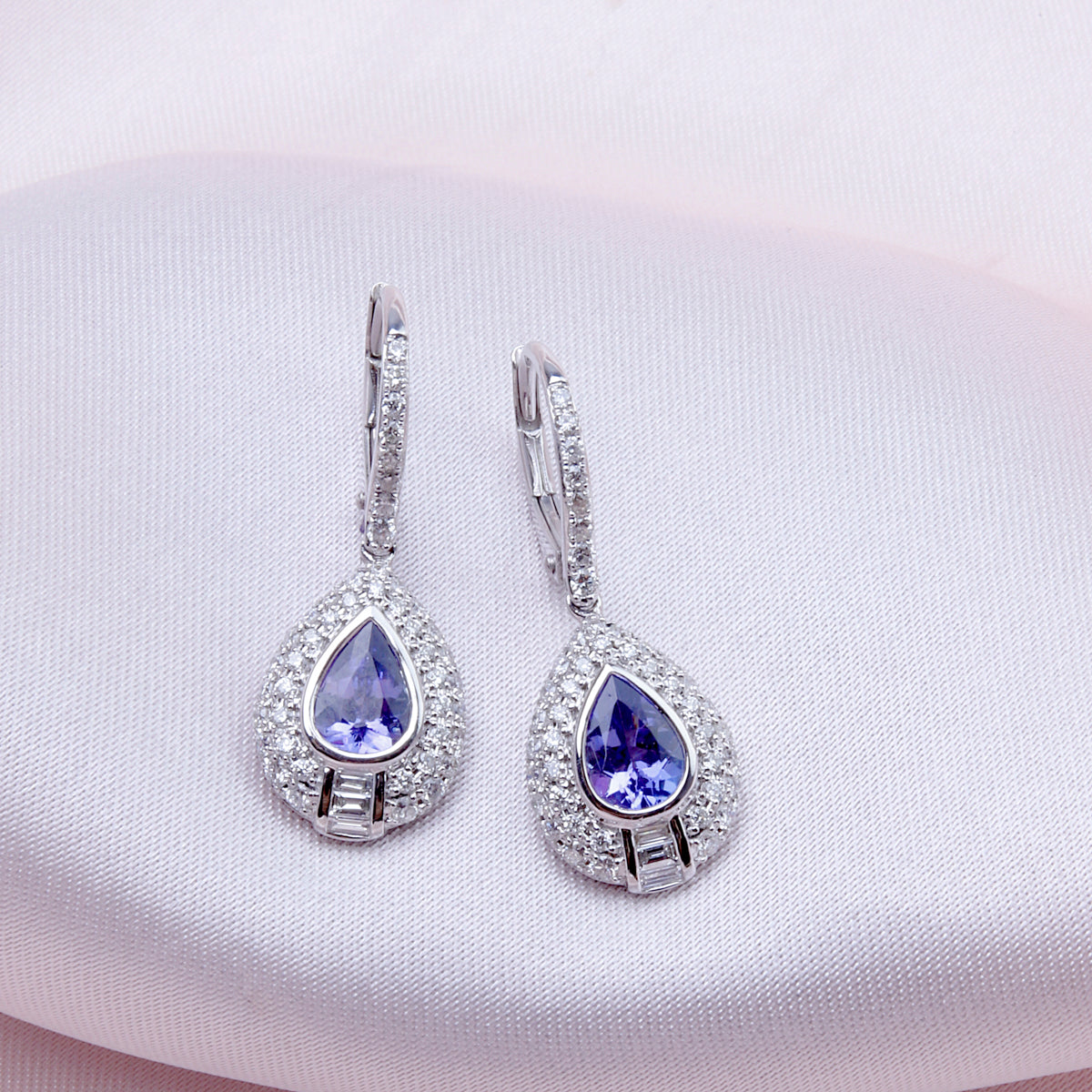 Precious stone teardrop cut earrings surrounded by a diamond halo. Effortless beauty for everyday