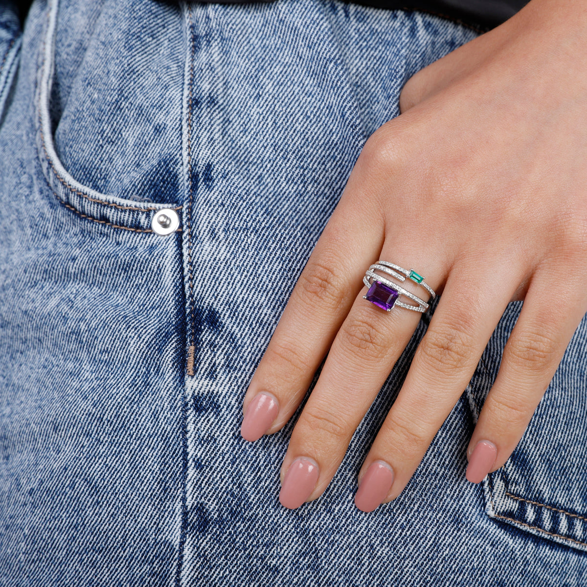 Luxurious ring showcases a semi-precious stone enveloped by three dazzling diamond bands