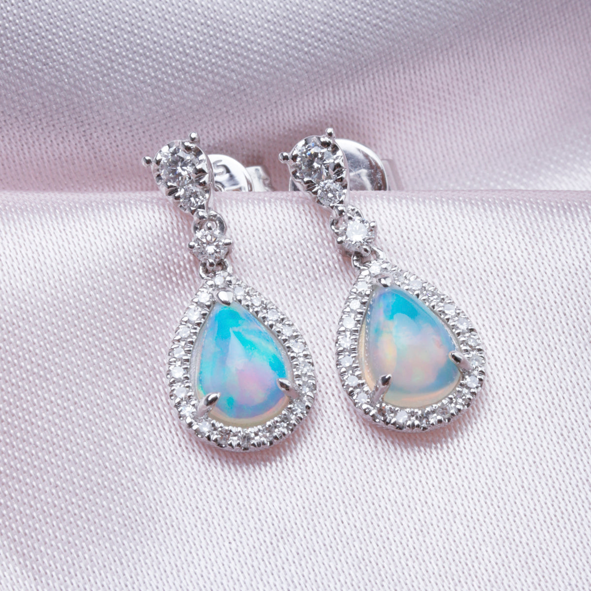 Opal Earrings in a dangle design with a diamond halo. Timeless and effortless beauty. 