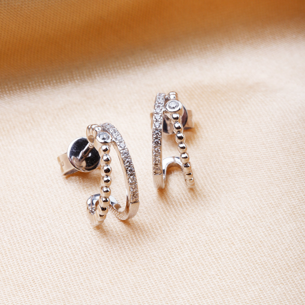 Double huggie earring adorned with beaded accents and diamonds. Secure and perfect size for everyday