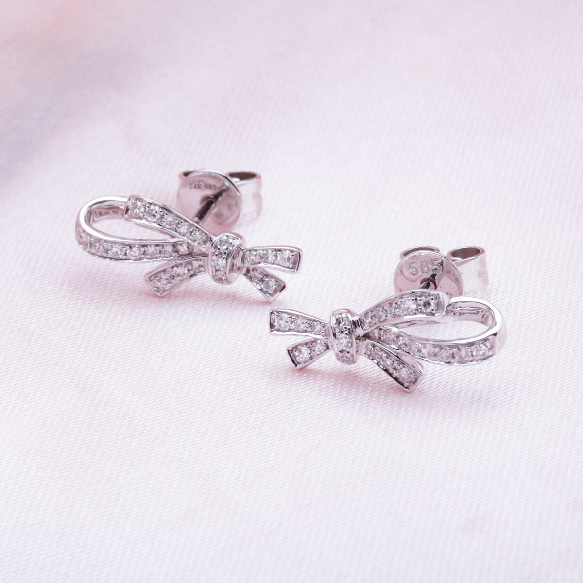 Diamond bow studs with pave set round diamonds. Crafted with fine details of intertwined bows.
