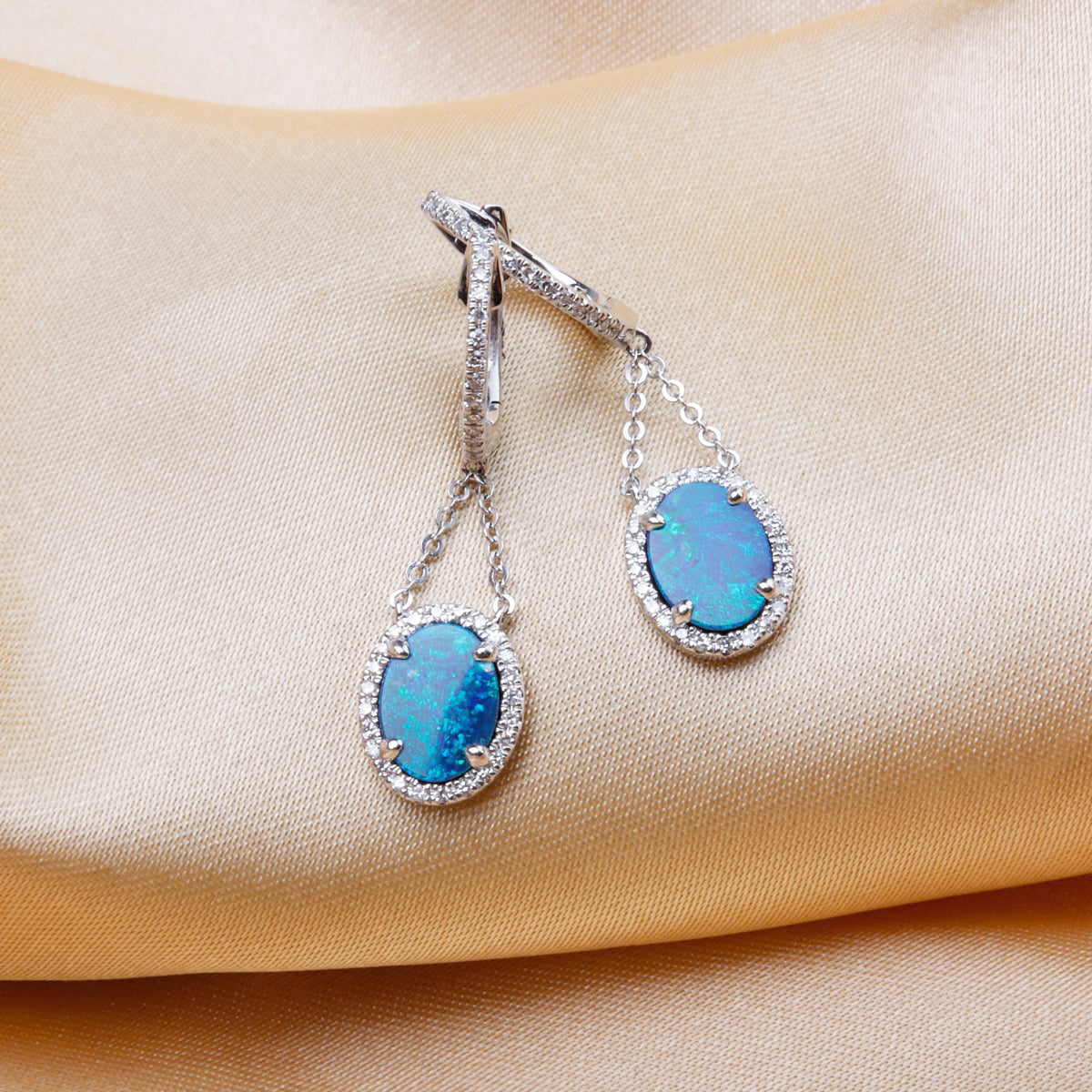 Opal Earring with a luxurious diamond halo held together by chains to flaunt opal by a dangle. 