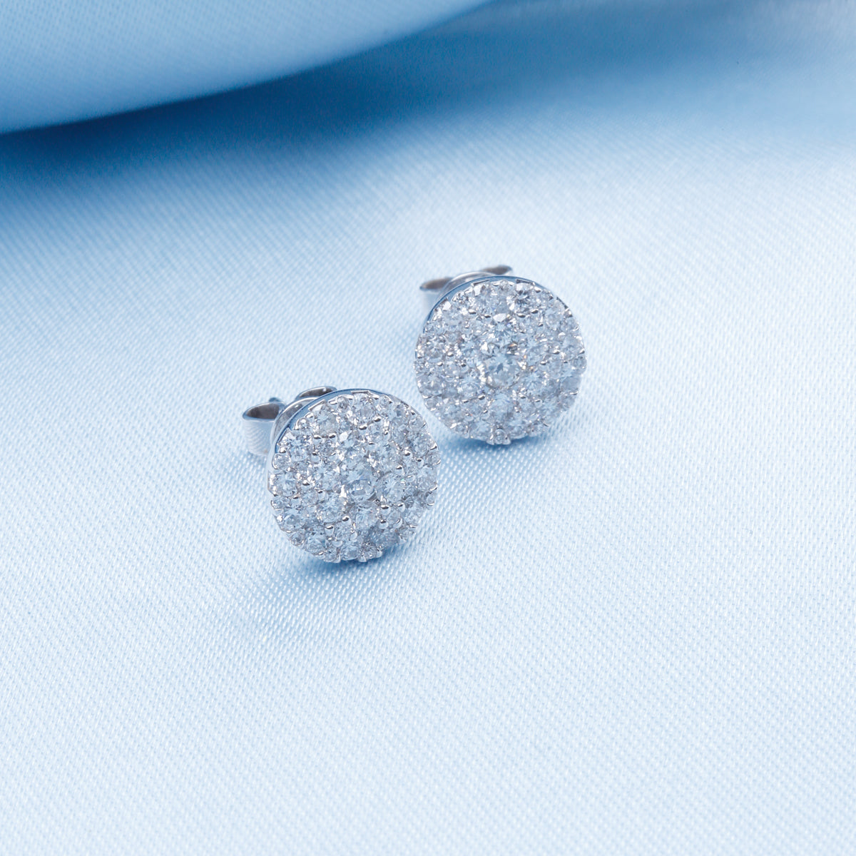 Cluster earrings feature a classic round diamond shape, held together with a platinum prong setting.