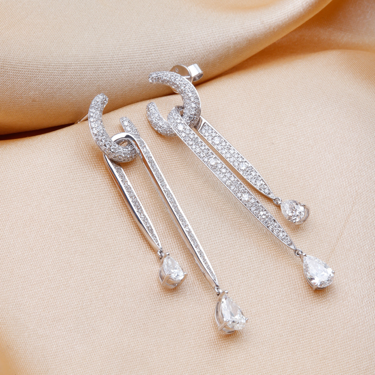 Bold diamond dangle earrings embellished with pear shaped diamonds and other pavé diamonds. 