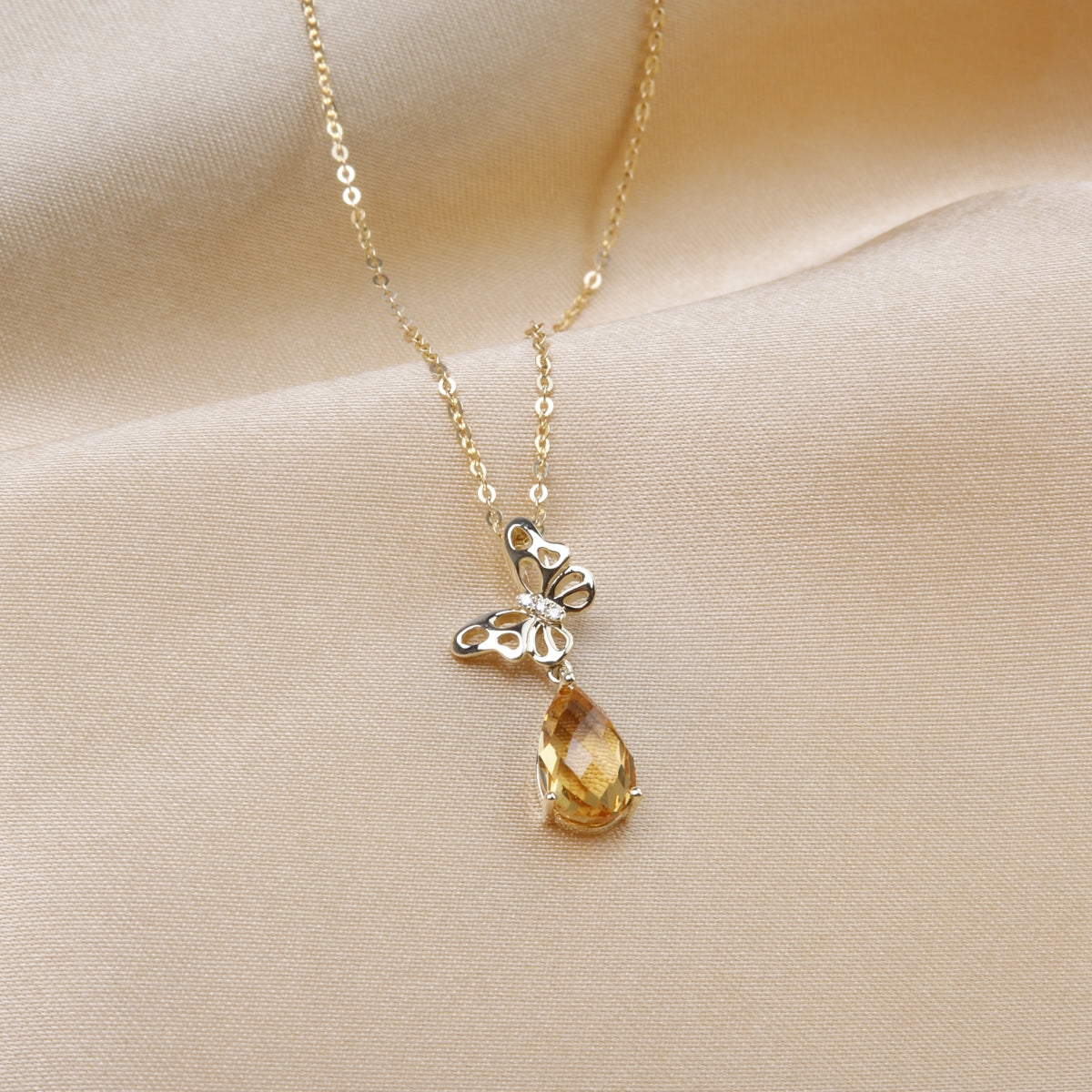 Timeless butterfly design in gold with a dangling gemstone. Variety of gemstone for self-expression