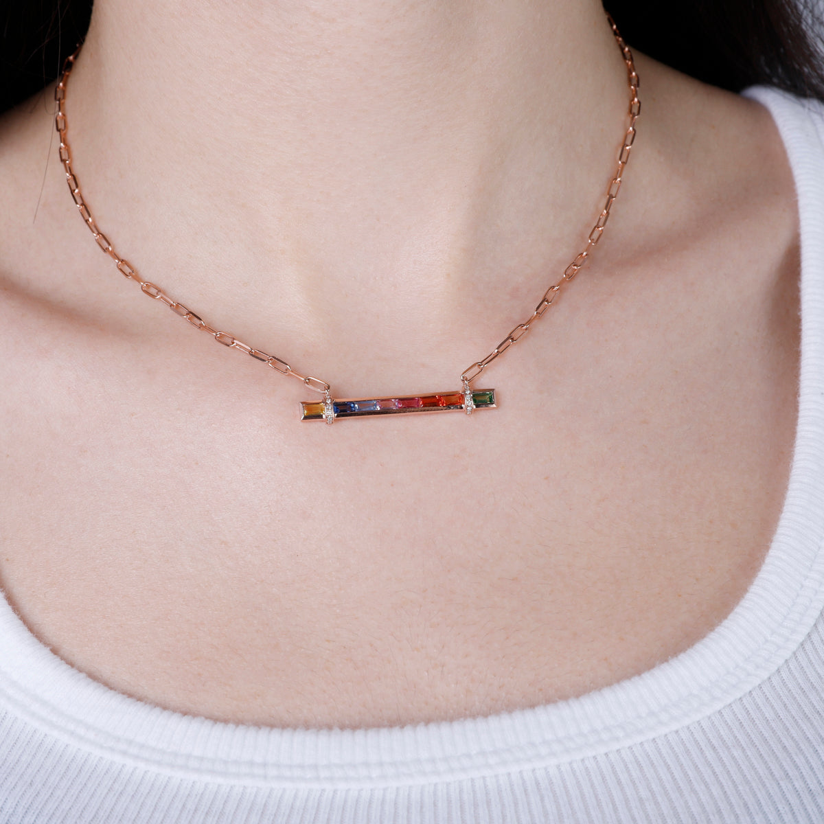 Candy Stripe Multicolor Necklace, a 14k gold bar adorned with a row of vibrant sapphire stones.