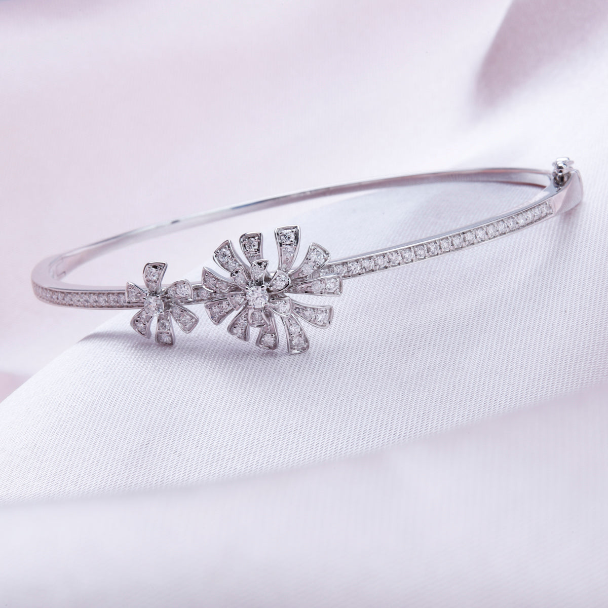 Feminine bangle features a centerpiece flower design of diamond stone studded petals.