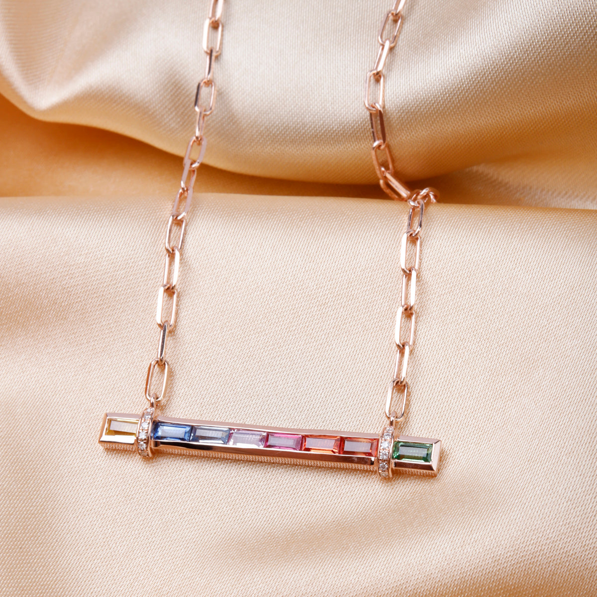 Candy Stripe Multicolor Necklace, a 14k gold bar adorned with a row of vibrant sapphire stones.