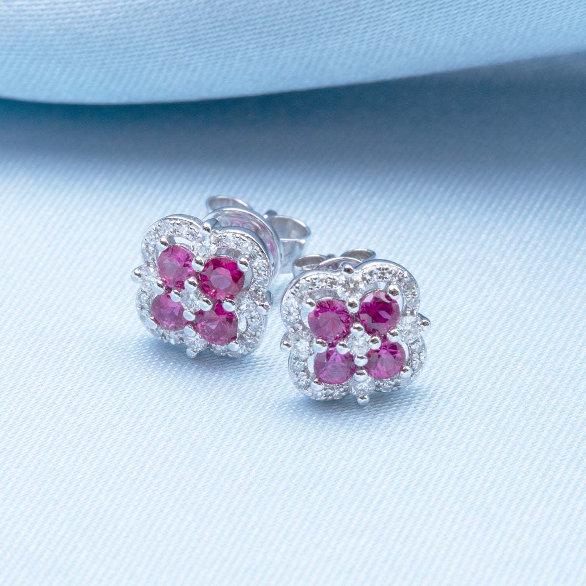 Inspired clover studs with precious stones allured with diamonds in a dazzling halo.