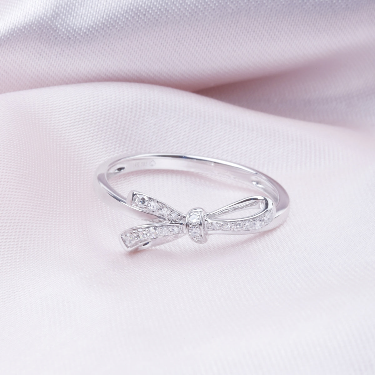Bow diamond ring is a luminous gold band and a dainty bow set with multiple diamonds.