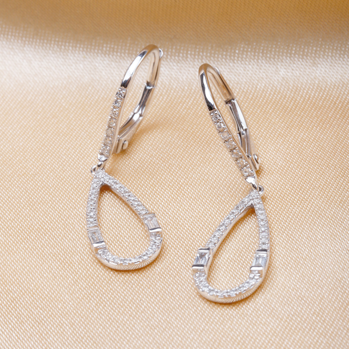 Baguette-cut gemstones carefully set along the teardrop outline. A leverback closure for secured fit