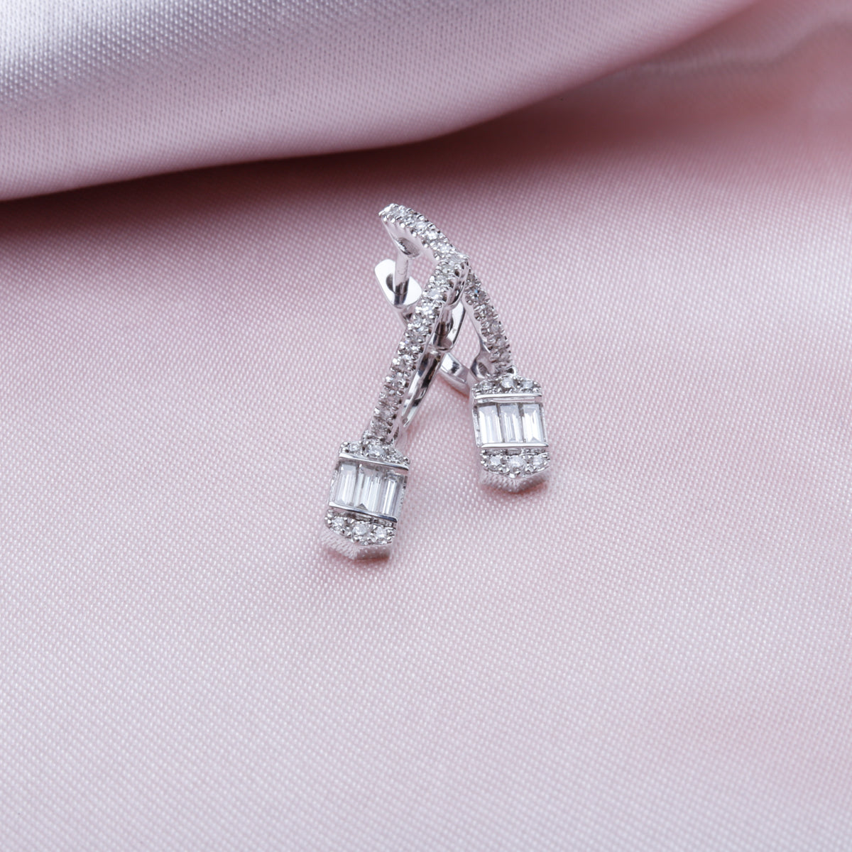 Baguette drop diamond earrings feature baguette-cut diamonds in a square setting.