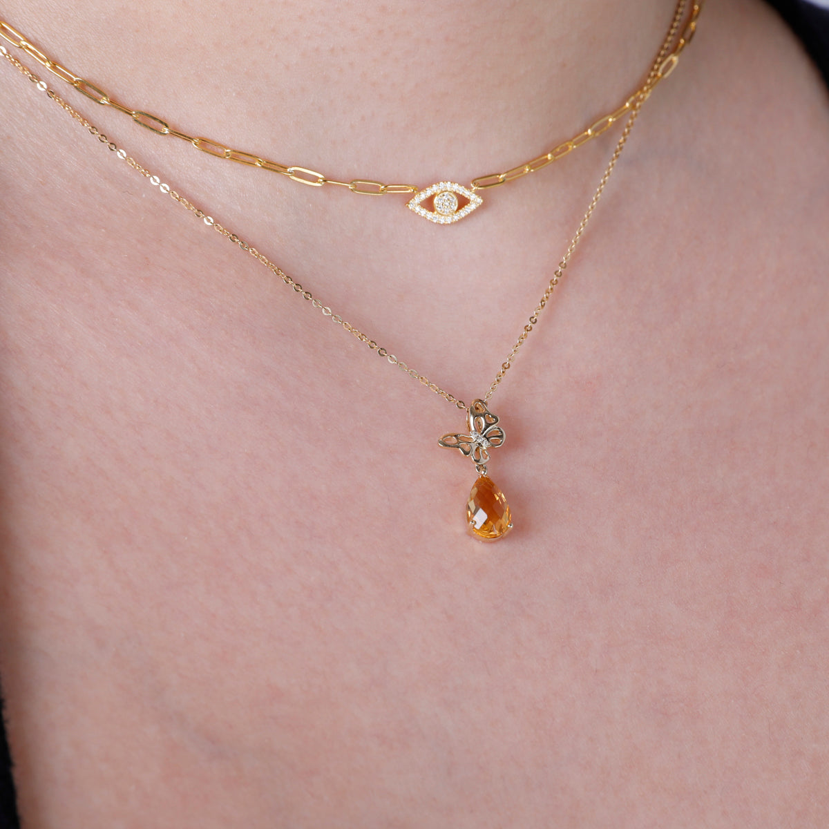 Timeless butterfly design in gold with a dangling gemstone. Variety of gemstone for self-expression