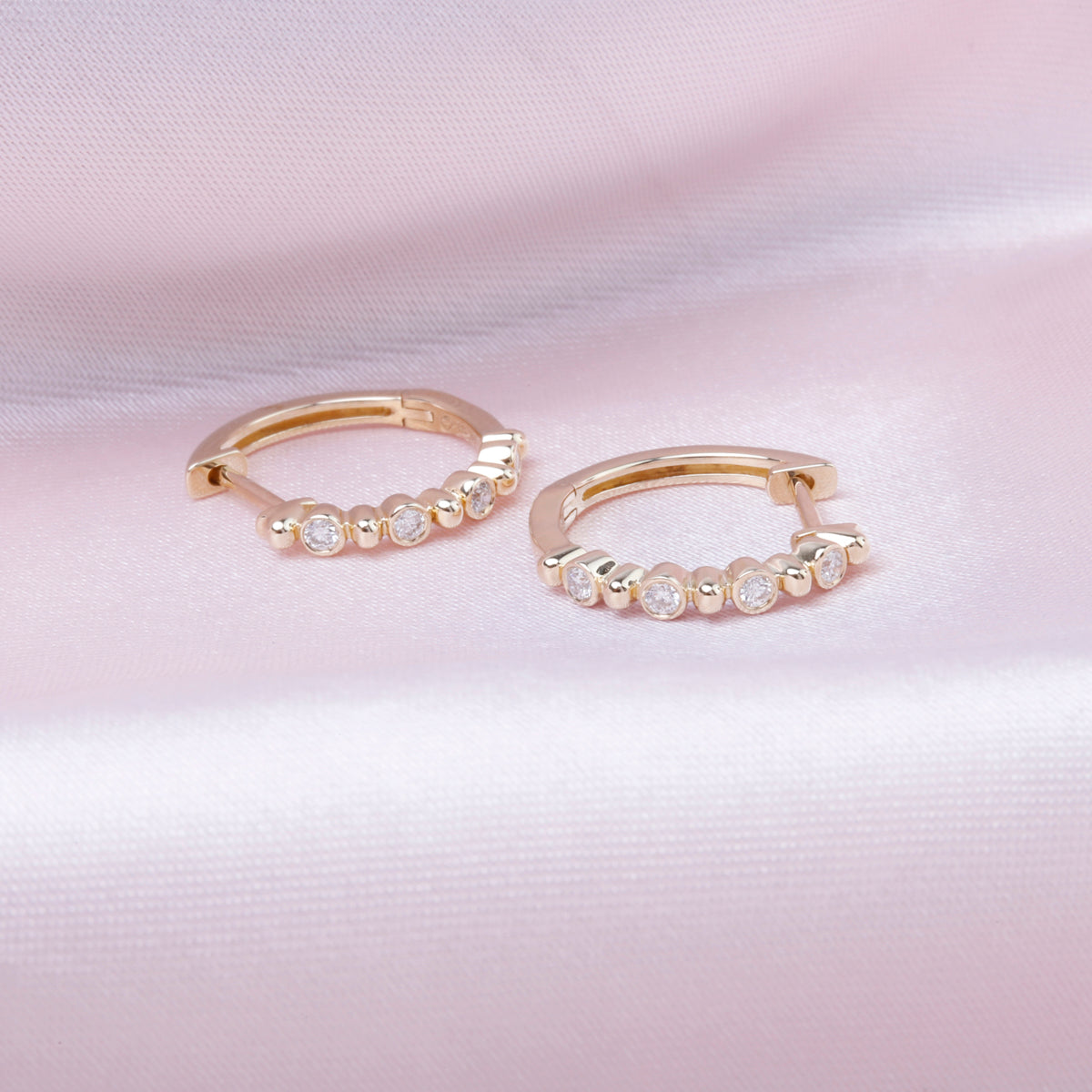 Bethany Diamond Hoop crafted in gold and adorned with round diamonds to create a simplistic pattern.
