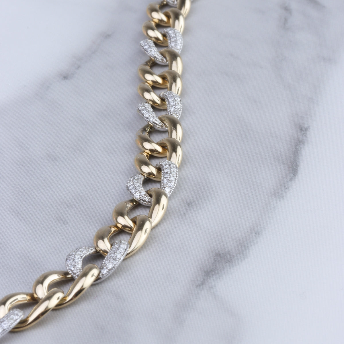 Gold chain bracelet with blend of shimmering diamond pavéd links and polished white gold.
